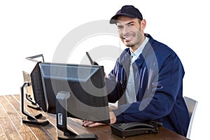 Happy Security officer talking on walkie-talkie while using computer