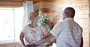 Happy senior african american couple dancing at home, slow motion