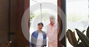 Happy senior african american couple opening door at retirement home