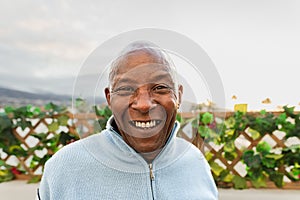 Happy senior African man smiling front of camera on house patio