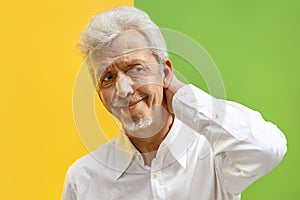 The happy senior business man standing and smiling against color background.