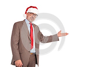 Happy senior business man wearing santa claus hat presenting