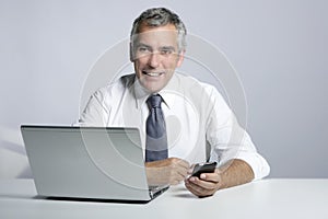 Happy senior businessman laptop mobile portrait