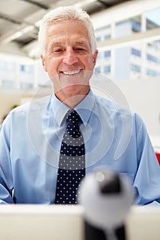 Happy senior businessman using Skype photo
