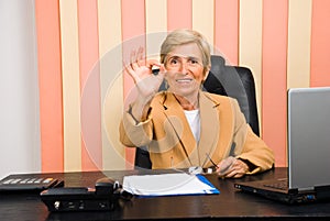 Happy senior businesswoman showing okay sign hand