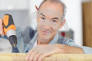 Happy senior carpenter at work