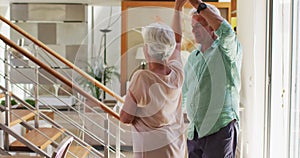 Happy senior caucasian couple dancing together at home