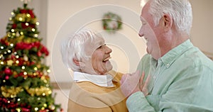 Happy senior caucasian couple spending time together at home at christmas, slow motion