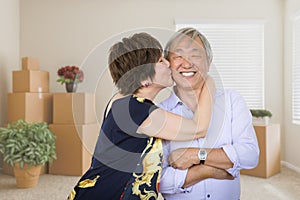 Happy Senior Chinese Couple Inside Empty Room with Moving Boxes