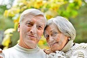 Happy senior couple in autumn park hugging