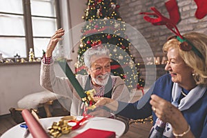 Senior couple wrapping Christmas presents photo