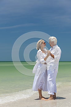 Happy Senior Couple Dancing Holding Hands on Beach