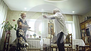 Happy senior couple dancing at home