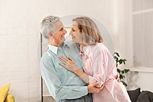 Happy senior couple dancing at home