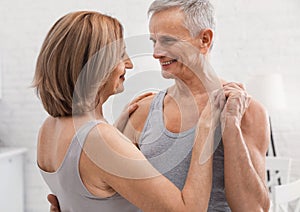 Happy senior couple dancing at home