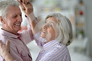 Happy senior couple dancing at home