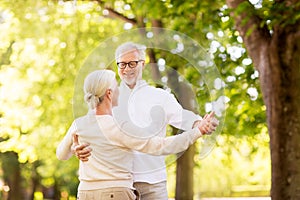 Happy senior couple dancing at summer park