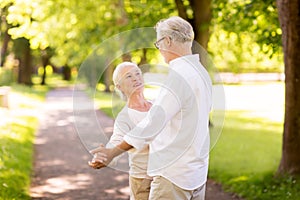 Happy senior couple dancing at summer park