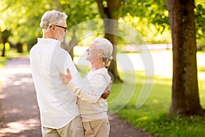 Happy senior couple dancing at summer park