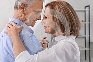 Happy senior couple dancing together at home