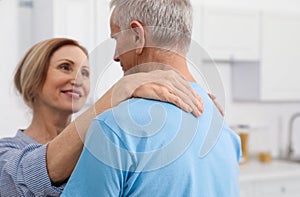Happy senior couple dancing together at home
