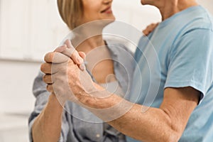 Happy senior couple dancing together at home