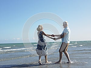 Happy Senior Couple Dancing On Tropical Beach