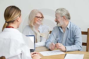 Happy senior couple discussing house purchase at meeting with ag