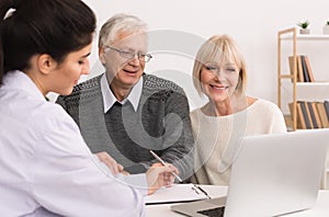 Happy senior couple discussing treatment plan with doctor