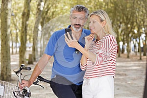 Happy senior couple doing selfie with bicycles