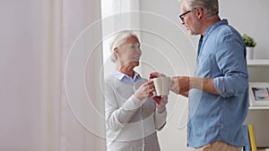 Happy senior couple drinking coffee at home