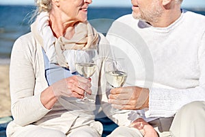 Happy senior couple drinking wine on summer beach