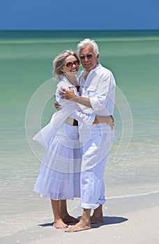 Happy Senior Couple Embracing on A Tropical Beach photo