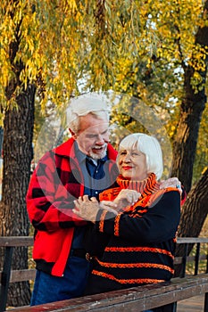 Happy senior couple enjoying each other in the park. Support and care from a loved one, warm emotions