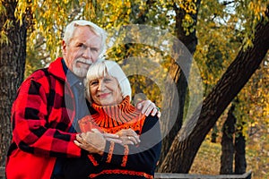 Happy senior couple enjoying each other in the park. Support and care from a loved one, warm emotions