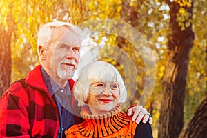 Happy senior couple enjoying each other in the park. Support and care from a loved one, warm emotions