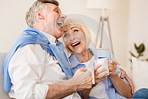 Happy senior couple enjoying tea and laughing