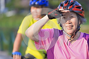 Happy  senior couple exercising with bicycles in the  park