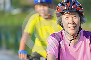 Happy  senior couple exercising with bicycles in the park