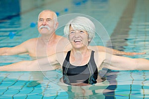 Happy senior couple exercising in swimming pool