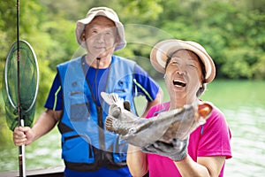 Happy Senior couple fishing at the lakeside