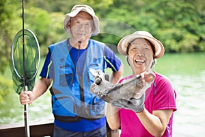 Happy Senior couple fishing at the lakeside