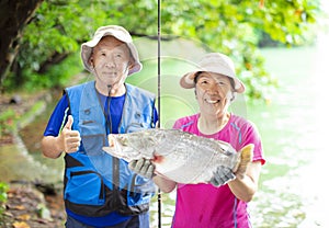 Happy Senior couple fishing at the lakeside