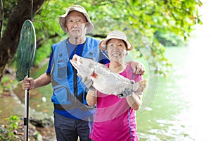 Happy Senior couple fishing at the lakeside