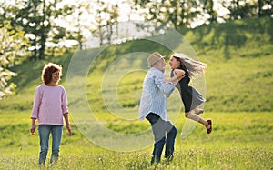 Senior couple with granddaughter outside in spring nature, having fun.