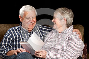 Happy senior couple with greeting card