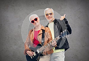 Happy senior couple with guitar showing thumbs up