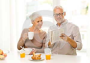 Happy senior couple having breakfast at home