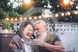 Happy senior couple having fun at dinner house party