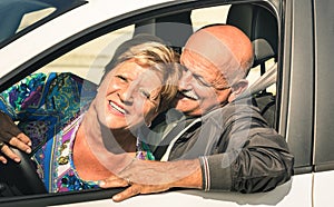 Happy senior couple having fun driving car trip on the road